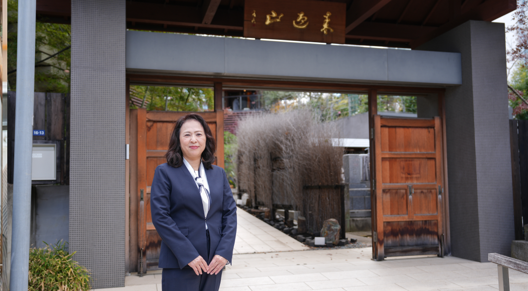 門の前に立つ女性